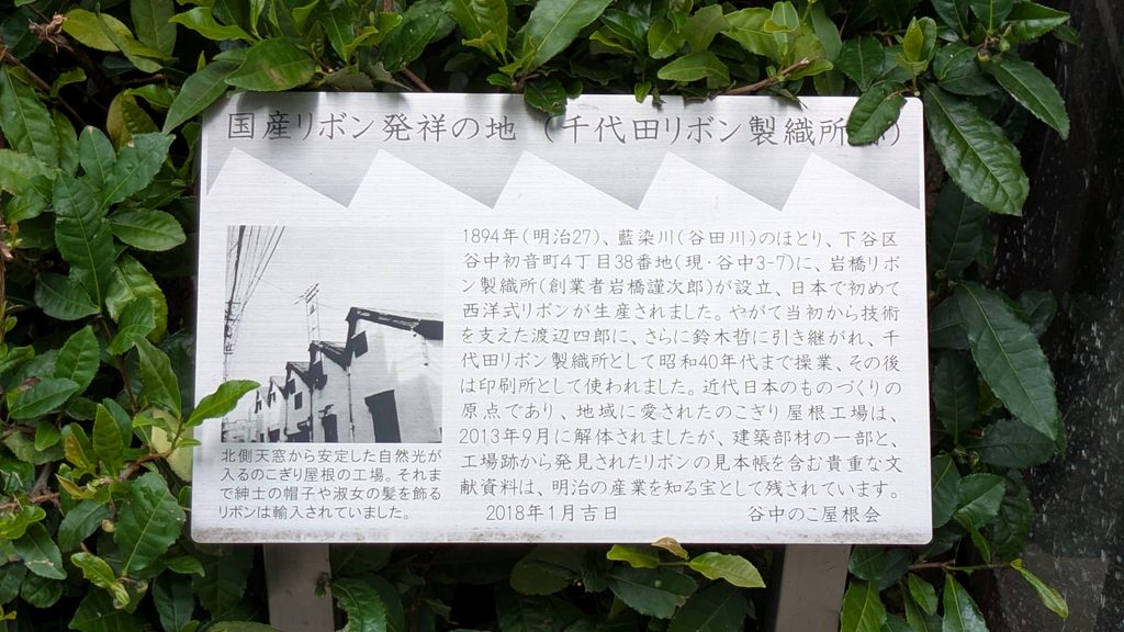 よみせ通りを南へ進むと、左手に「国産リボン発祥の地(千代田リボン製織所跡)」の案内板があります。1894年に藍染川のほとりでリボン工場が設立され、日本で初めて西洋式リボンが生産されたことが記されています。