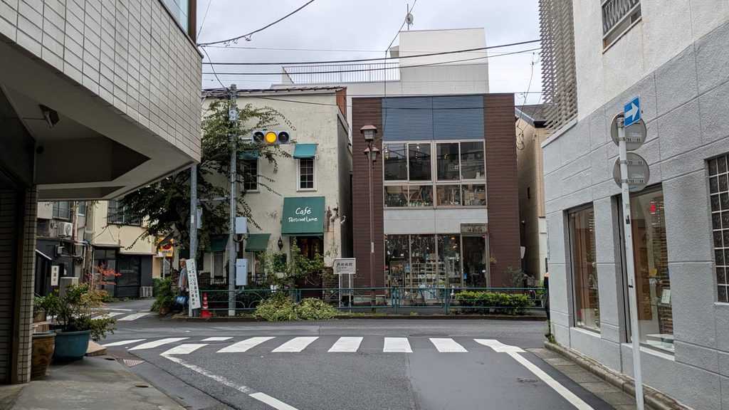 正面に枇杷橋跡が見える交差点に着きます。横切る道路は柳通りです。左へ行くと三崎坂・谷中霊園方面、右へ行くと不忍通り・団子坂方面です。写真左端には、次の区間へ続くへび道の入口も見えています。