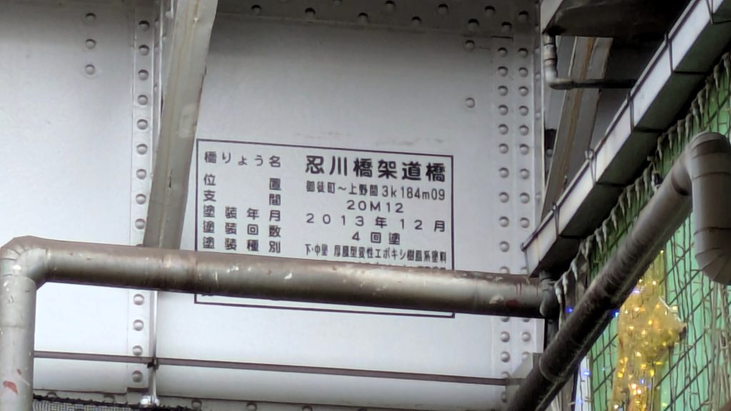 ガード下には「忍川橋架道橋」と記された表示があります。忍川の名が鉄道施設の名称として現在も残っています。
